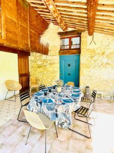 une chambre avec une table, des chaises et une porte bleue dans l'établissement Mas Provençal en Drôme, à Condorcet