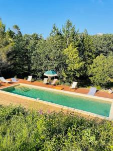 - une piscine avec des chaises et un parasol dans l'établissement Mas Provençal en Drôme, à Condorcet