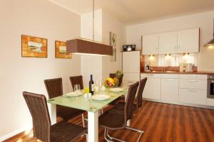 a dining room table with chairs and a kitchen at Villa Marin Wohnung 21 in Zinnowitz