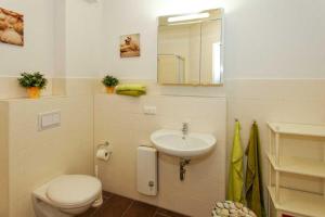 ein weißes Bad mit einem WC und einem Waschbecken in der Unterkunft Villa Marin Wohnung 21 in Zinnowitz