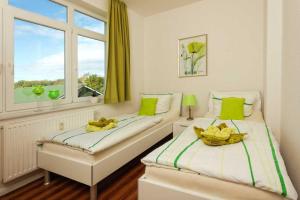 two beds in a room with a window and bananas at Villa Marin Wohnung 21 in Zinnowitz