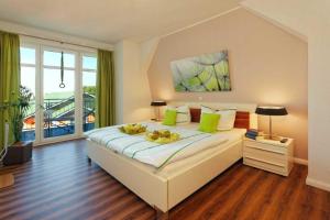 1 dormitorio con 1 cama blanca grande con almohadas verdes en Villa Marin Wohnung 21 en Zinnowitz