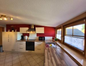 een keuken met rode muren en een groot raam bij Ferienwohnung Beim Ivo in Roßhaupten