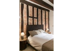- une chambre avec un lit doté d'une grande tête de lit en bois dans l'établissement "L'Appart" Vieux Tours - Charme - Place Plumereau - Arrivée Autonome, à Tours