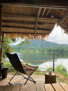 a chair on a deck with a view of a lake at Royal mountain lake view in Ratchaburi