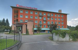 un grande edificio arancione con un cartello sopra di Hilton Garden Inn Milan Malpensa a Somma Lombardo
