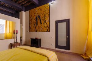 een slaapkamer met een geel bed en een spiegel bij “Lo Scrigno” della Corte di Corso Cavour in Foligno