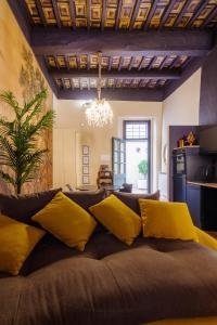 een woonkamer met een bank met gele kussens bij “Lo Scrigno” della Corte di Corso Cavour in Foligno