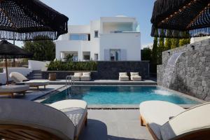 a swimming pool with chairs and a villa in the background at EPICENTER LUXURY RESIDENCE in Mesaria