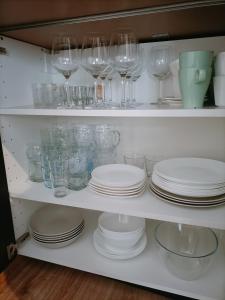 a shelf filled with glasses and plates and dishes at Czarna Chata in Jaworzynka