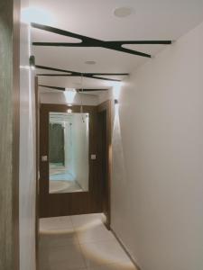 a hallway with a ceiling and a mirror at Hotel Happy Stay in Ahmedabad