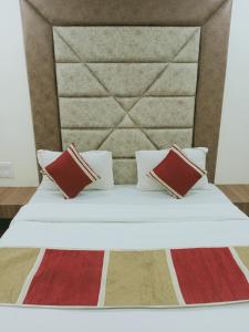 a bed with two pillows and a headboard at Hotel Happy Stay in Ahmedabad