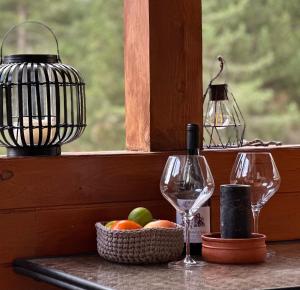 a table with two wine glasses and a basket of fruit at Spacious penthouse chalet apartment in Pirin Golf and Country Club in Razlog