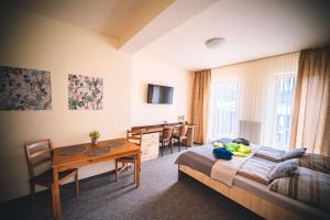 a bedroom with a bed and a table and a dining room at Wellness & Spa Hotel Čertov in Čertov