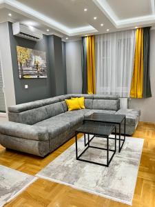 ein Wohnzimmer mit einem Sofa und einem Tisch in der Unterkunft Apartman Central in Banja Luka