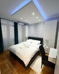 ein Schlafzimmer mit einem großen Bett und einem blauen Licht in der Unterkunft Apartman Central in Banja Luka
