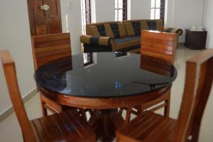 a dining room table with chairs and a couch at HILLFORT HOMESTAY in Vagamon