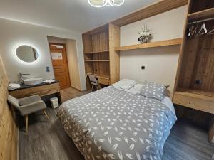 een slaapkamer met een bed, een bureau en een wastafel bij Hôtel Plein Soleil in Vacheresse