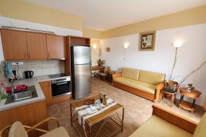 Tris Ekklisies Beachfront Apartment - Ammos في Paránimfoi: مطبخ وغرفة معيشة مع أريكة