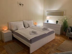 a bedroom with a large white bed with two towels on it at Appartement Bohème Budapest in Budapest