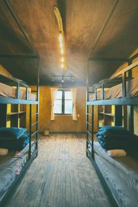 a room with three bunk beds and a window at Maison de Hill Home in Dồng Văn