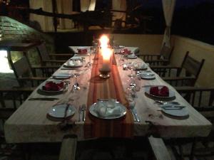 a long table with a candle and plates and silverware at Mikumi Wilderness Camp in Kikoboga