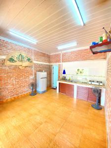 a large room with a brick wall and wooden floors at Lều biệt thự in Hanoi
