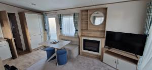 D4 Dove Close في Goodrington: غرفة معيشة صغيرة مع تلفزيون وطاولة