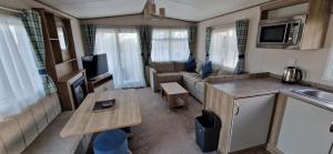 D4 Dove Close في Goodrington: غرفة معيشة مع أريكة وطاولة في كرفان