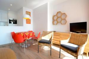 レスカラにあるApartamentos Passeig Del Marのリビングルーム(テーブル、椅子、テレビ付)