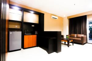 a living room with a couch and a table at Parkside Mandarin Hotel Pekalongan in Pekalongan