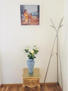 un jarrón de flores en una mesa junto a una pintura en Dúplex Palacio de los Momos, en Zamora