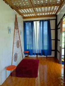 a living room with two chairs and blue curtains at FrancoEly's A Family Camp in Daliao