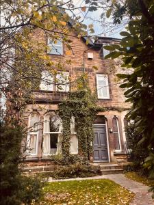 a brick house with ivy growing on the front of it at The Penthouse - Cosy Central Apartment - Free Parking in Harrogate