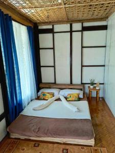 un grande letto in una stanza con tende blu di FrancoEly's A Family Camp a Daliao