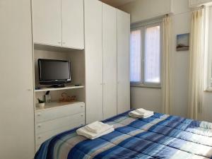 a white bedroom with a bed and a tv at Guest House Baia dei Sogni in Rapallo