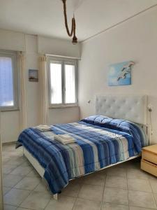a bedroom with a bed with a blue and white comforter at Guest House Baia dei Sogni in Rapallo