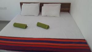 a bed with two pillows and two towels on it at Hotel 4u Udawalawe in Udawalawe