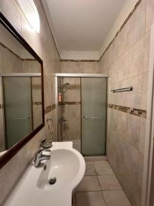 y baño con lavabo y ducha. en Villa Saint George Stone Costa Demetriou, en Káthikas