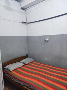 een slaapkamer met een bed met een kleurrijk gestreepte deken bij New Star Lodge in Colombo