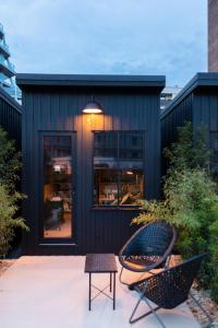 een zwart huis met een tafel en stoelen op een patio bij Hôtel Lilybloom in Le Havre