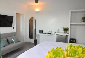 Royal-Ma Resort في Perástra: غرفة نوم مع سرير وغرفة معيشة مع أريكة