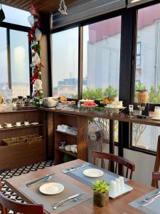河內的住宿－The Cosy Inn Hanoi，一间带桌子和一些窗户的用餐室