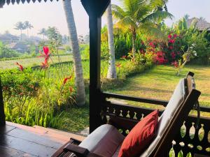 eine Veranda mit einem Sofa und Gartenblick in der Unterkunft Villa Neyang in Ubud