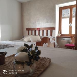 una camera con due letti e un tavolo con un piatto di fiori di Casa Gaudia a Castello Tesino