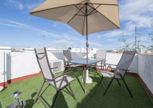 a table and chairs with an umbrella on a roof at Solymar in Chipiona