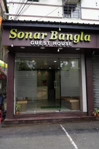una tienda frente con un cartel para una casa de huéspedes en Sonar Bangla Guest House, en Calcuta