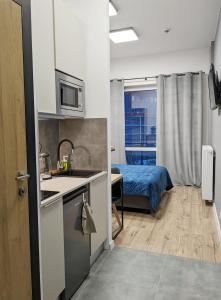 a kitchen with a sink and a bed in a room at Twój dom in Warsaw