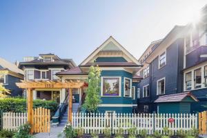 a house with a white fence in front of it at Heart of Downtown Restored Heritage Home in Vancouver