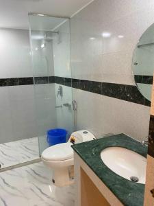 a bathroom with a toilet and a glass shower at Hotel Grand Akther Sylhet in Sylhet